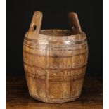 A 19th Century Coopered Barrel composed of bowed pine staves with integral lug handles,