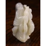 A 19th Century Chinese Bi-colour Jade Carving of a Sage carved from white stone with a ram at his