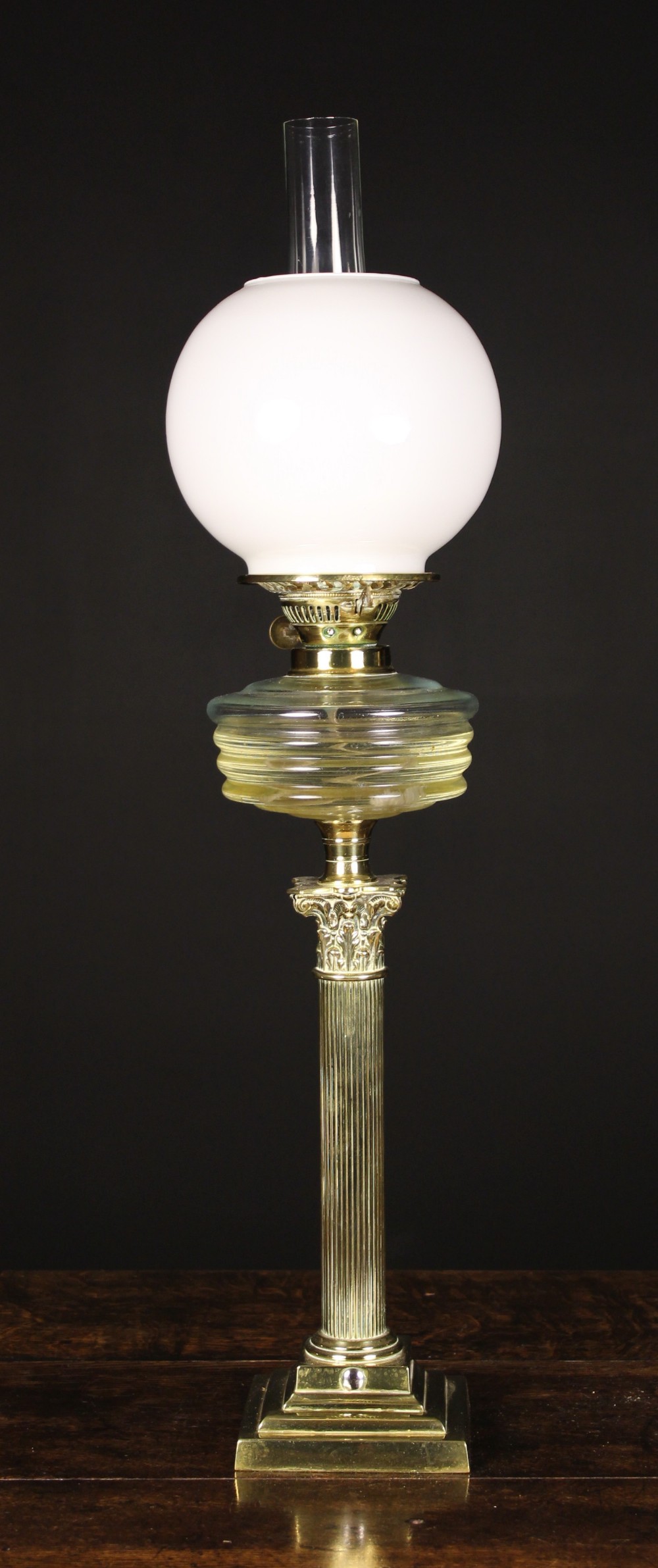 A Brass Oil Lamp having a reeded columnar stand with Corinthian style capital and stepped square