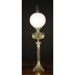 A Brass Oil Lamp having a reeded columnar stand with Corinthian style capital and stepped square