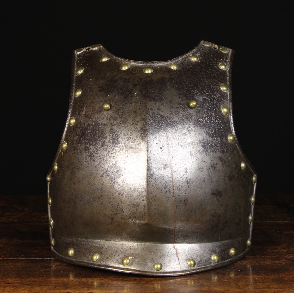 A 17th Century Breast Plate edged in brass studs with a chain of punch-work to the border.