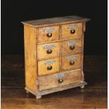 A Late 19th Century Oak Spice Cabinet fitted with six small drawers set in pairs above a long