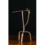 An 18th Century Wrought Iron Peerman with a twisted stem on tripod base 15 ins (38 cms) in height.