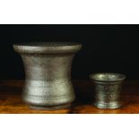 Two Late 17th/18th Century Iron Mortars, One 11½ ins (29 cms) high, 13 ins (33 cms) in diameter,