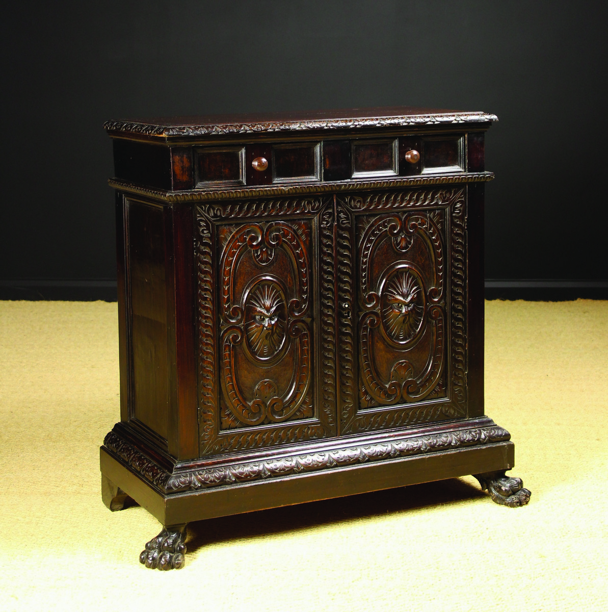 A 19th Century Italian Carved Walnut Credenza with two frieze drawers above cupboard doors centred