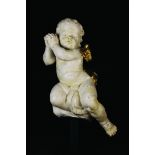 A 17th Century Wood Carving of a Fleshy Cherub, painted white with gilded wing and flowing drape,