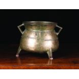 A 17th Century Bronze Cauldron with triangular lug handles, 8½ ins (21.