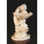 A White Glazed Figural Comport modelled in the form of a cherub and scaly dolphin bearing a shell