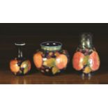 Three Pieces of 1920's Moorcroft decorated with pomegranate design on a dark blue ground: A bulbous