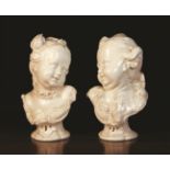 A Pair of Nymphenburg White Glazed Busts of 18th Century Children after Bustello.