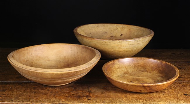 Three Treen Dairy Bowls: Two 19th century sycamore bowls 20½ ins (52 cms) and 19 ins (48 cms) in