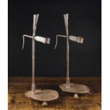 A Pair of Wrought Iron Candle / Rush Holders on tray bases with voluted strap feet,