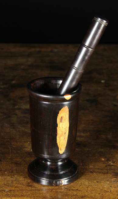 A Turned Lignum Vitae Pestle & Mortar. The mortar 6½ ins (16 cms) high on a pedestal foot.