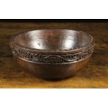 A Turned Oak Bowl with a chip carved edge and a border of carved undulating vine,