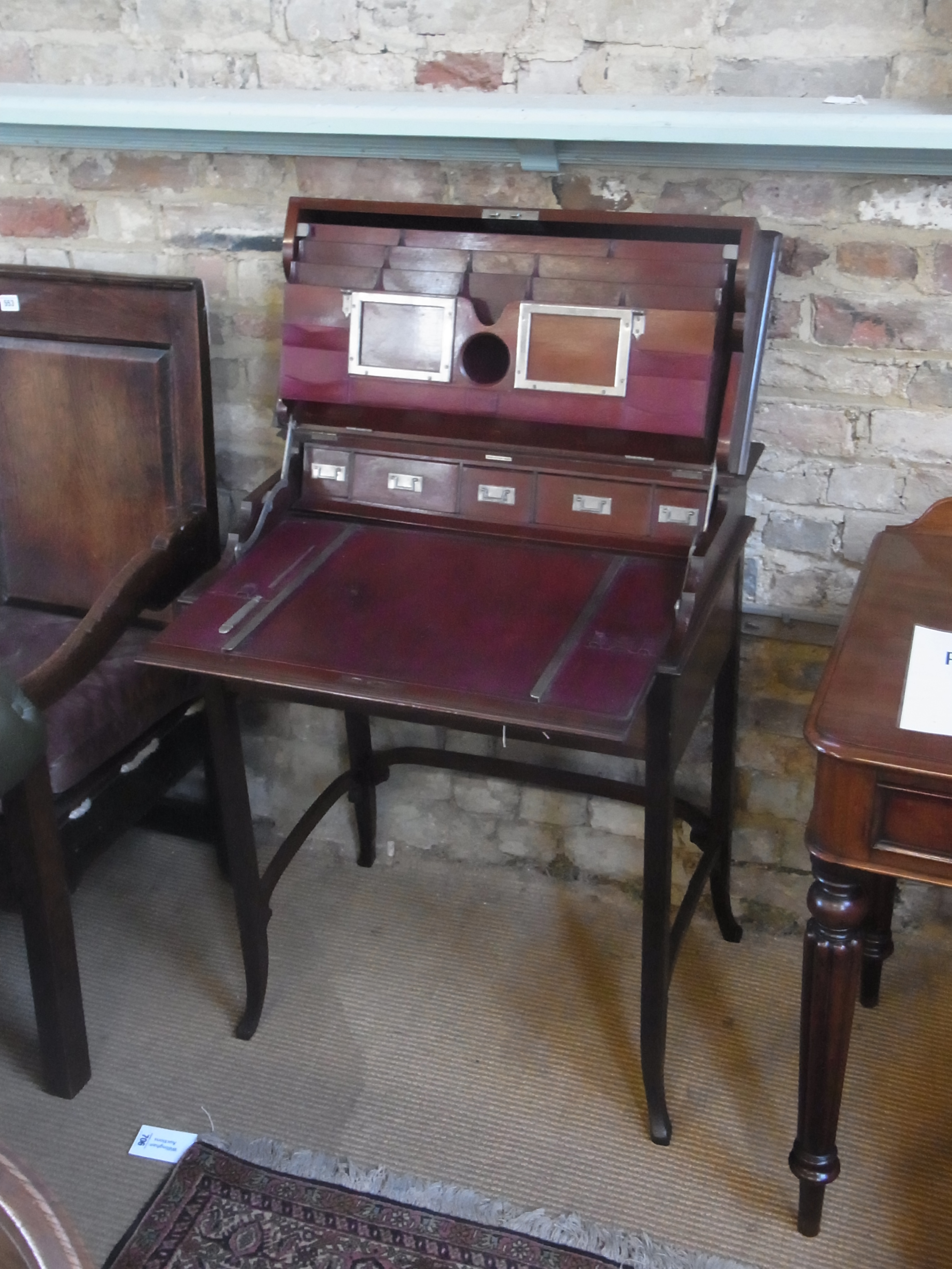 An Edwardian mahogany Campaign writing desk with lift up top  revealing a fitted interior of