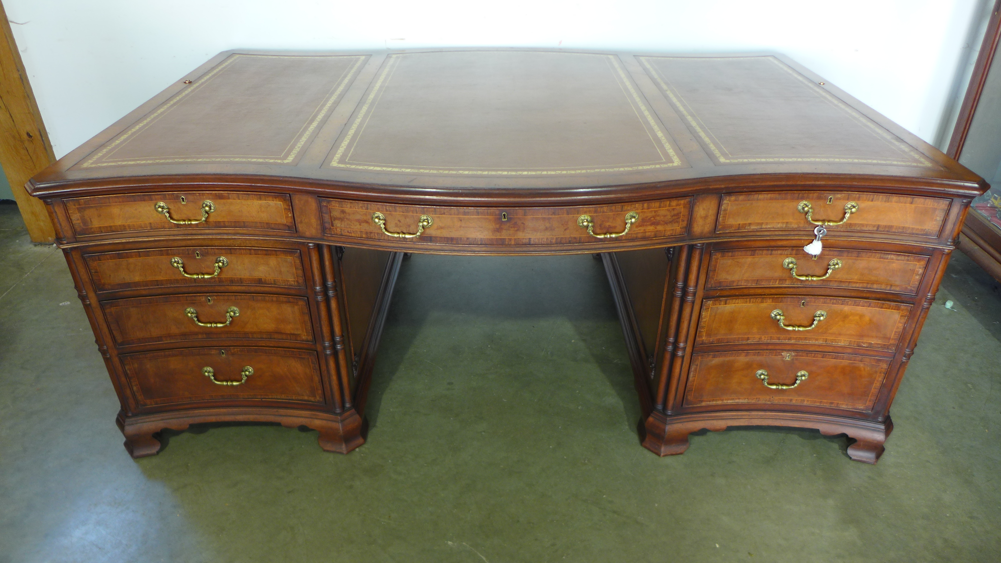 A good quality 20th century walnut and rosewood crossbanded serpentine fronted partners desk with