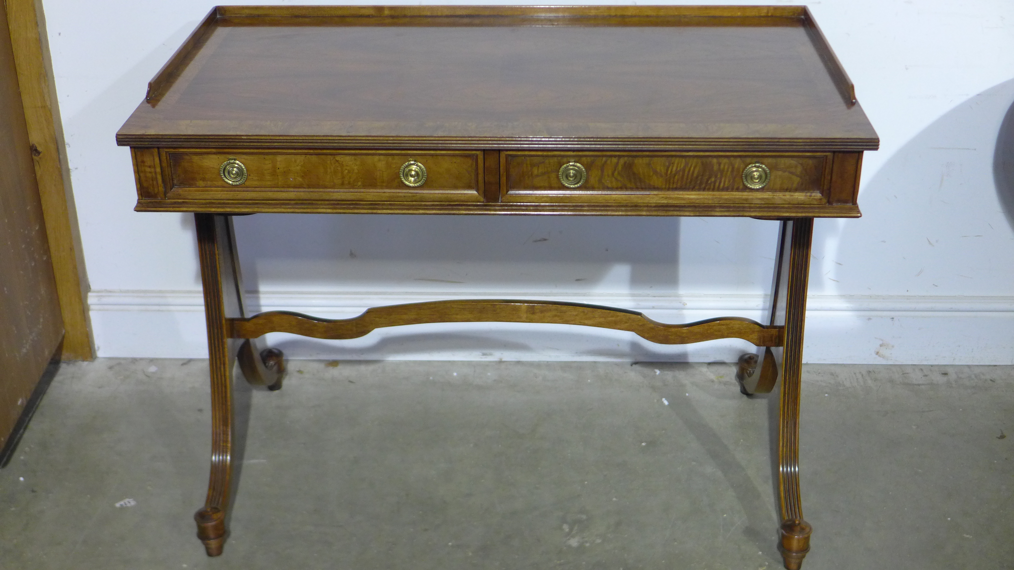 A good quality mahogany and walnut cross banded writing table with 3/4 gallery surround to top,