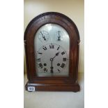 An oak cased German chiming mantle clock with a silvered dial with a pendulum and key - Height 34cm