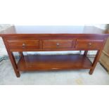 A mahogany sideboard/buffet of three drawers over open enclosure with tier below raised on square