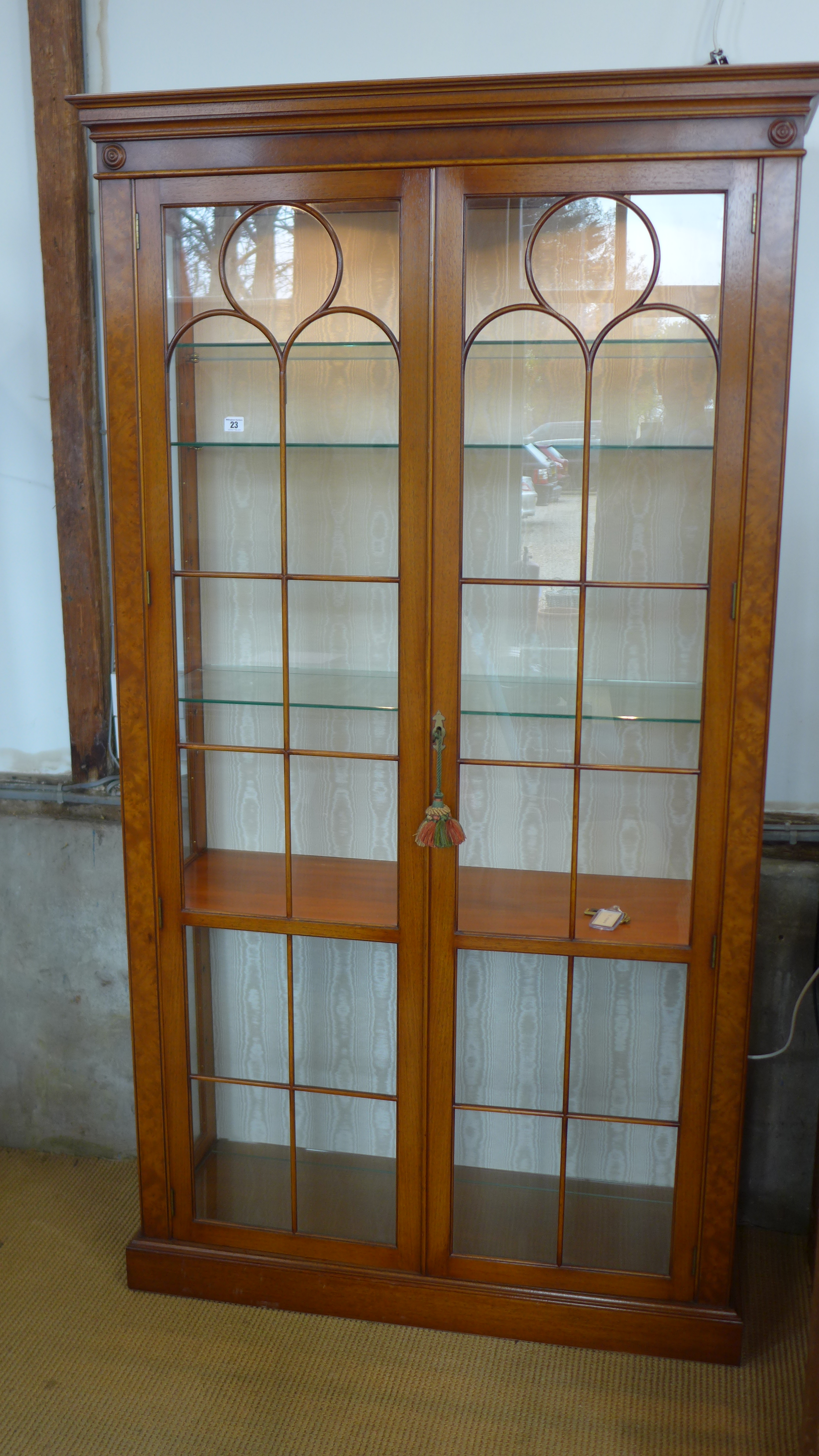 A Reprodux walnut effect full height display cabinet with two glazed doors,