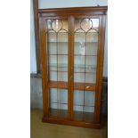 A Reprodux walnut effect full height display cabinet with two glazed doors,