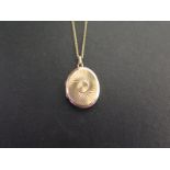 A 9ct gold locket - With textured swirl detail - Length 2.