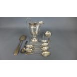 A silver hallmarked milk jug, two silver stainer spoons,