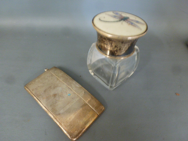 A silver card case and a silver top bottle with ivory insert decorated with a dragonfly,