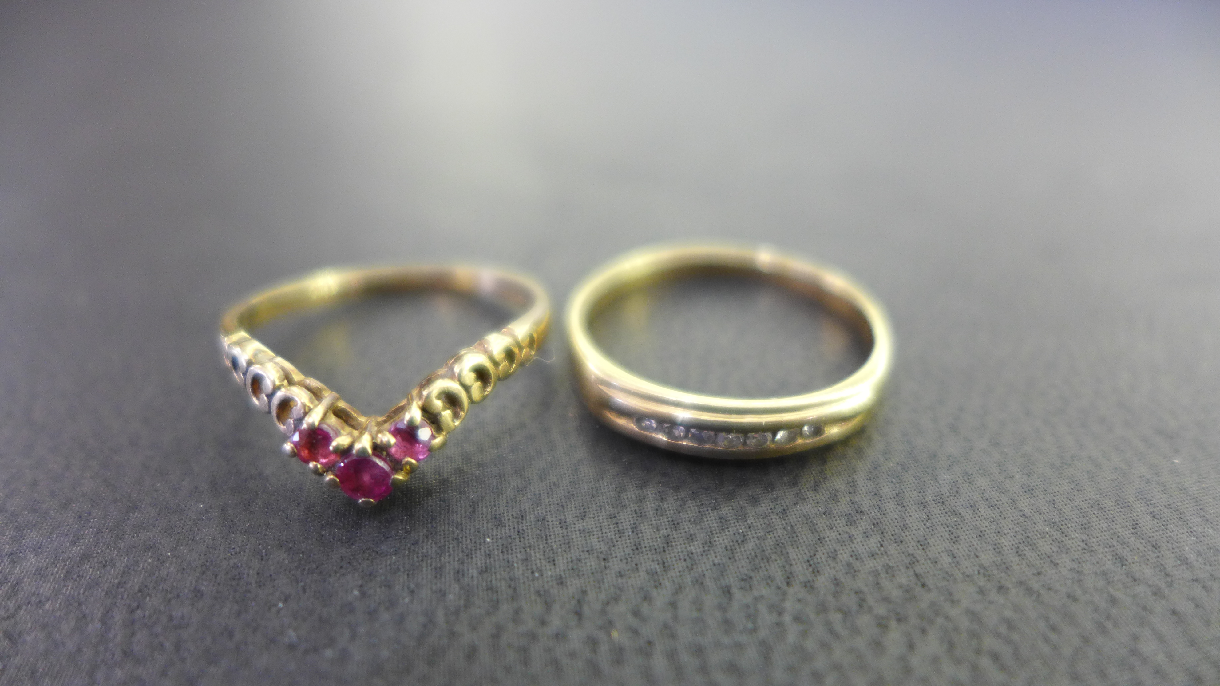 A 9ct gold diamond band ring - Size L - Together with a 9ct gold ruby chevron-shape ring - Size J -