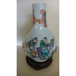 A late 19th century/20th century Oriental famille verte bottle neck vase on an associated wooden