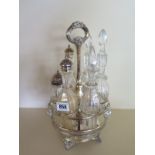 A plated six bottle carousel condiment with rams head decoration - all bottles except one vase
