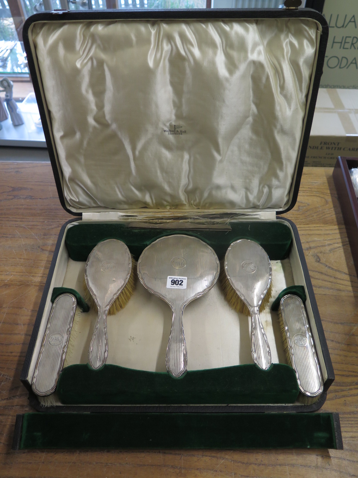 A Walker and Hall six piece silver backed dressing table set in original box generally good some