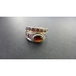 A 9ct gold garnet crossover ring - Hallmarked London - Ring size M - Weight approx 3.