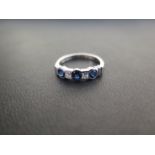 A platinum sapphire and diamond five-stone ring - With circular sapphires and princess-cut diamonds