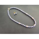 A black cultured pearl set - Comprising necklace and ear studs - Necklace stamped 750 - Length