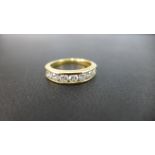 An 18ct gold diamond half-circle ring - The seven brilliant-cut diamonds within a channel setting