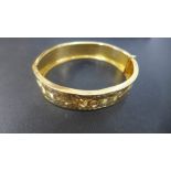 A gold bangle with engraved decoration tested to approx 20ct - 7cm x 6cm - approx weight 29 grams