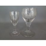 Two antique glasses one with fruit vines etched decoration on single fluted stem and one smaller