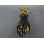 A Georgian bronze door knocker in the form of a hand holding fruit,