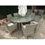 A Bramblecrest oval table 197cm x 150cm along with eight armchairs with cushions and a parasol