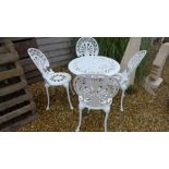 A painted metal garden table and four chairs