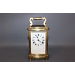 An early 20th century Carriage clock, full face white enamel dial with Roman numerals,