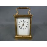 A brass cased carriage clock, white enamelled dial with Roman numerals to chapter ring,