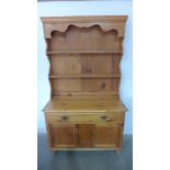 A stripped pine dresser with an open rack top above a drawer and two cupboard doors 187cm tall x