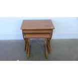 A nest of three retro style teak table with shaped end supports