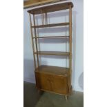 An Ercol light elm room divider with a shelved top above two cupboard doors - some usage marks but