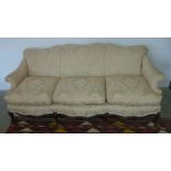 A late 19th century/early 20th century mahogany upholstered three seat sofa with scroll arms on