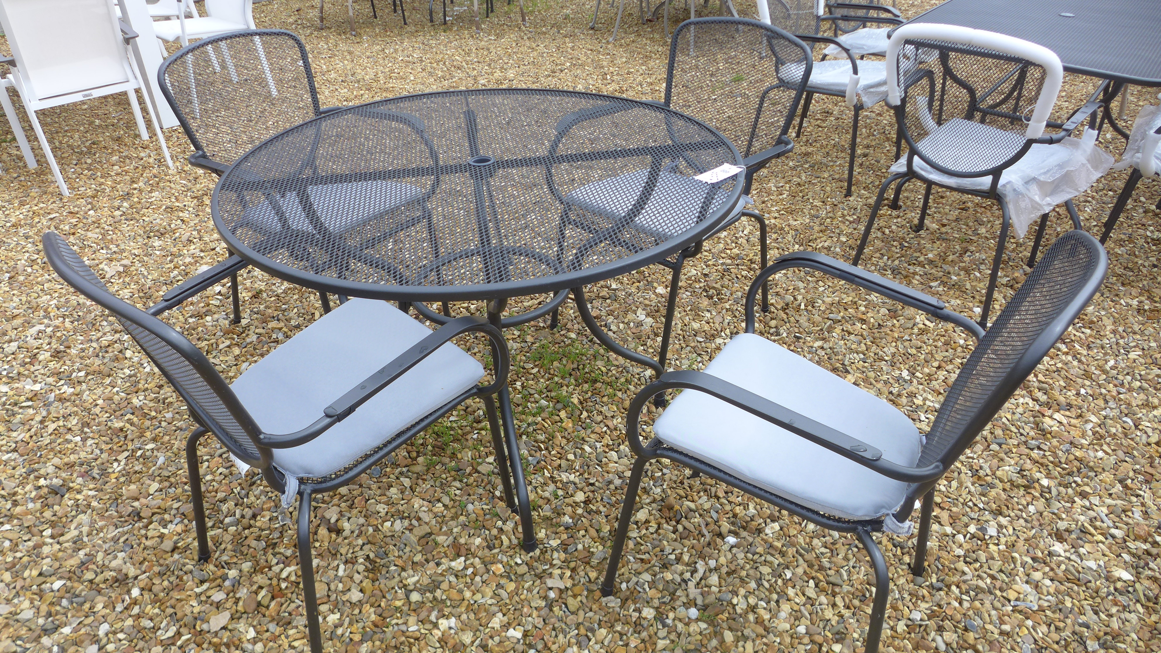 A Bramblecrest Atlantic mesh round table - Diameter 110cm with four chairs and cushions