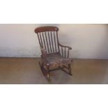 A 19th century elm rocking Windsor chair with bobbin twist back and arms