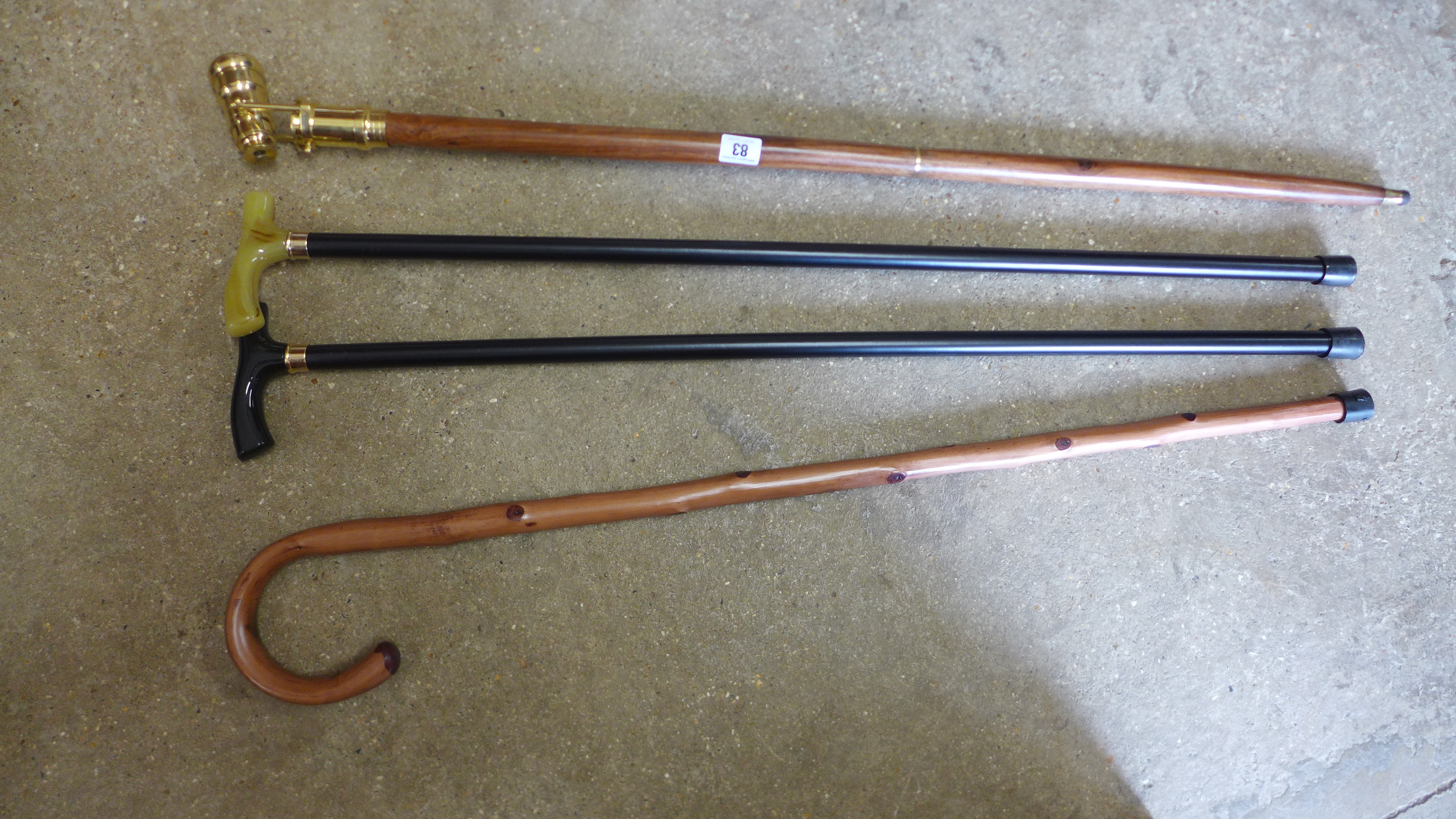 A brass handle walking stick with telescope in handle plus three other walking sticks